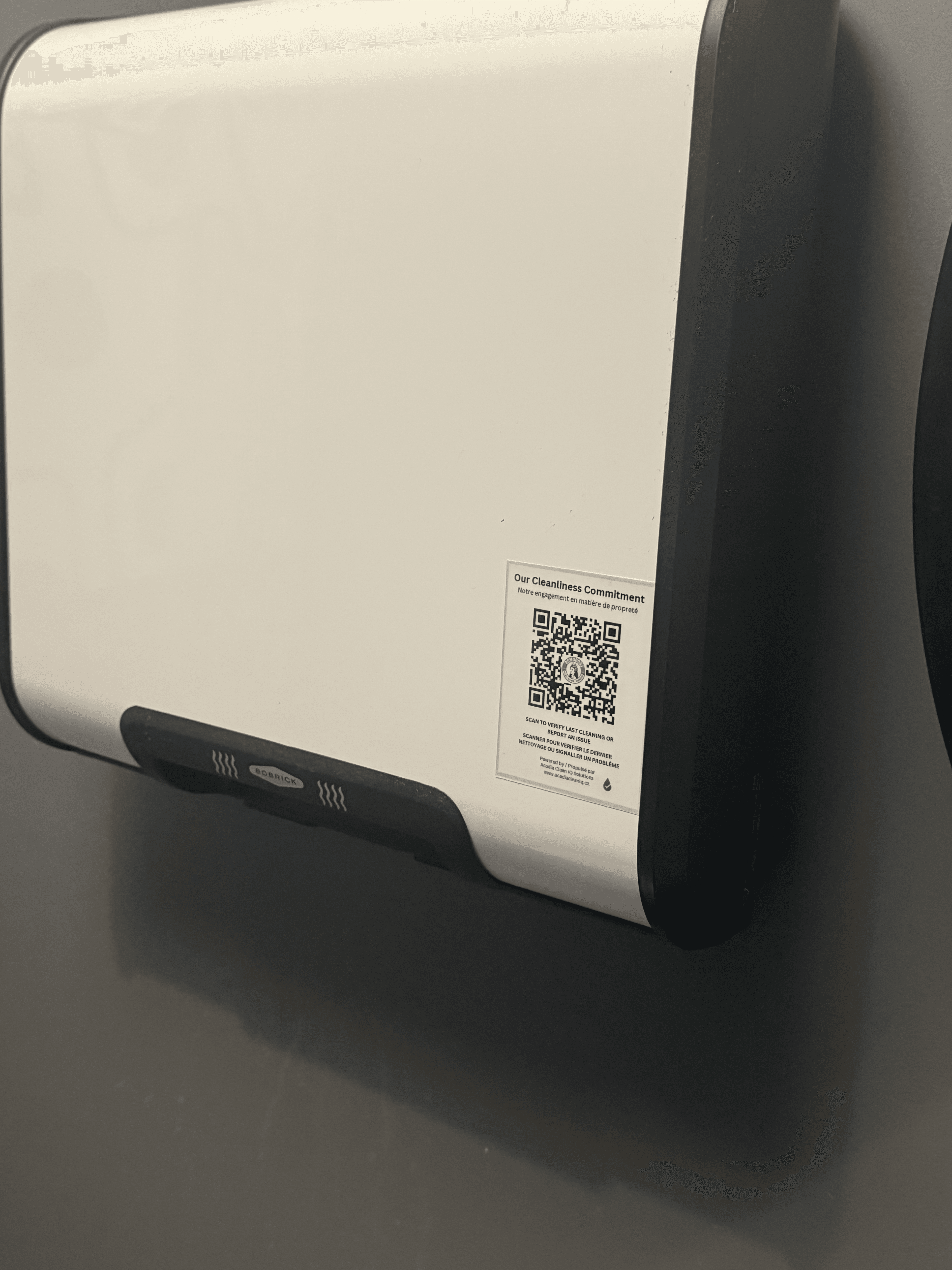 Acadia CleanIQ QR code mounted on a facility dispenser in Moncton, NB